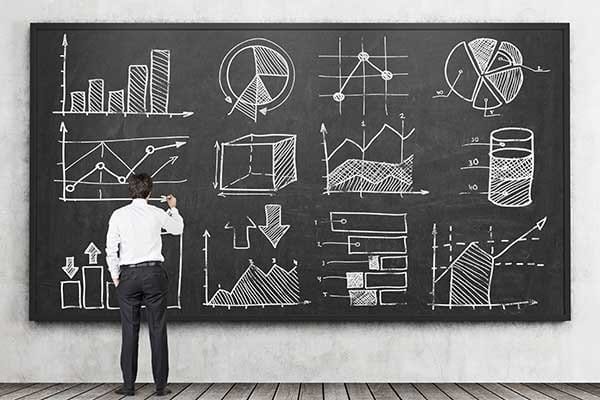 Investor studying business data on blackboard Investor studying business data on blackboard